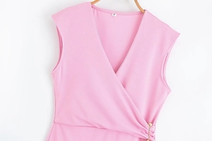 Détail de la robe rose sans manches à col en V avec décoration d'épingle dorée