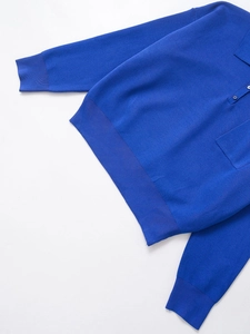 Detailed view of royal blue long-sleeve polo shirt featuring a chest pocket and ribbed cuffs