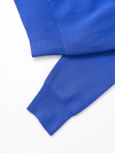 Detail of royal blue polo top featuring premium ribbed cuffs and knit fabric texture