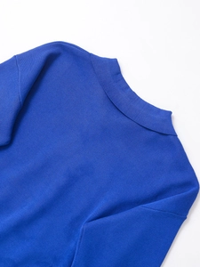 Detailed close-up of Klein blue knit sweater collar and fine ribbed texture