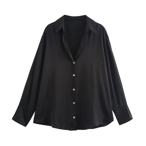 Dettaglio di un'elegante camicia oversize in raso nero con texture liscia e bottoni
