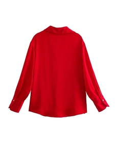Dettaglio del retro di una camicia di raso rosso con trama liscia e colletto classico