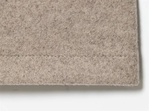 Dettaglio delle cuciture lisce e della morbida trama in misto lana beige della giacca