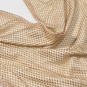 Detail of champagne gold mesh fabric with sparkling rhinestones on an halter dress