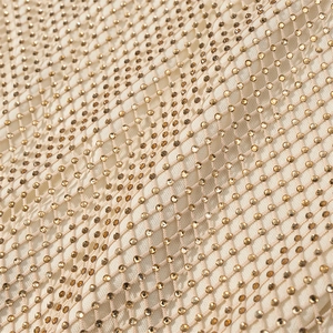 Macro detail of breathable mesh fabric with shimmering gold rhinestones and sequins