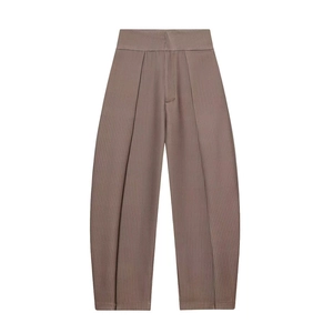 Detail einer hoch taillierten braunen Faltenhose mit vertikaler Streifenstruktur und weitem Bein
