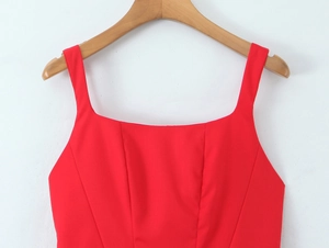 Close-up view of a vibrant red square neck dress with wide straps on a wooden hanger.