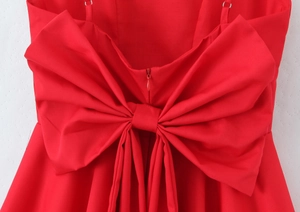 Detail showing the elegant large red bow and hidden zipper on back of mini dress.