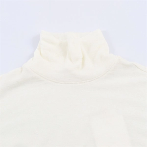 Dettaglio ravvicinato del collo alto e delle doppie cuciture su un top in maglia bianco crema