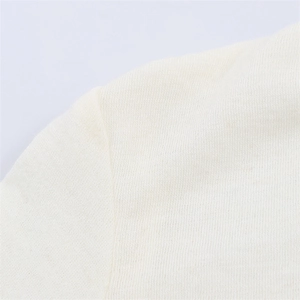Dettaglio macro delle cuciture precise sulla trama del tessuto a maglia bianco crema
