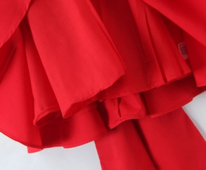Detailed close-up showing the high-quality vibrant red fabric layers and texture of a mini dress