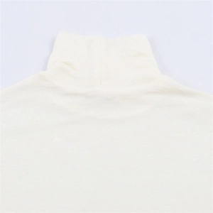 Dettaglio dell'elegante dolcevita asimmetrico bianco sporco e trama del tessuto a maglia