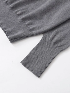 Detailed macro view of the ribbed cuffs and hem on this grey fine knit sweater