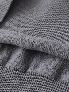 Close-up of the grey knit sweater showing soft ribbed texture and premium fabric details