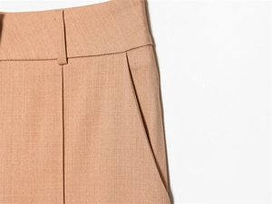 Détail du pantalon de costume camel à taille haute avec poches latérales et tissu tissé
