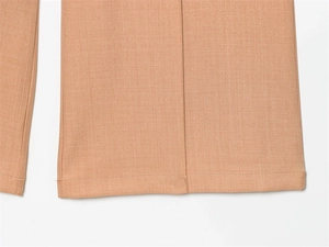 Vue macro du pantalon kaki montrant la texture sergée fine et l'ourlet professionnel