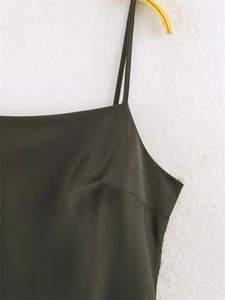 Gedetailleerde close-up van donkergroene satijnen camisole met dunne bandjes