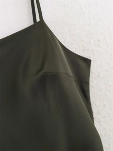 Detailopname van donker olijfgroene satijnen camisole met fijne horizontale stiksels