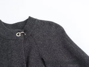 Detalle de chaqueta de punto gris oscuro con un cierre de anillo metálico en el cuello