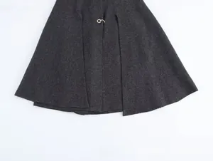 Detalle de la capa de lana gris oscuro con textura de sarga y hebilla de anillo metálico