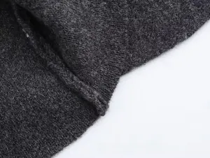 Primer plano de tela de punto gris oscuro que muestra la textura tejida y detalles de fibra