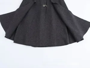 Vista detallada de la textura de lana gris carbón y el broche metálico plateado en el bajo
