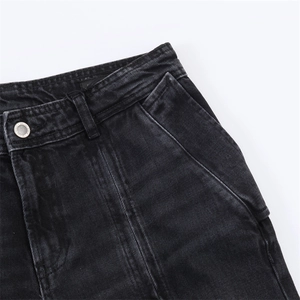 Gros plan sur le jean noir délavé avec bouton métallique et poches à double surpiqûre