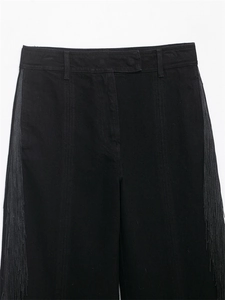 Gros plan sur le pantalon noir droit avec franges latérales élégantes et coton sergé