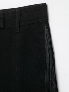 Gros plan d'un pantalon en denim noir avec bordure à franges et passants de ceinture