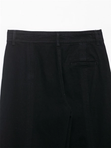 Vue détaillée du pantalon en jean noir montrant les coutures et la poche passepoilée