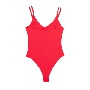 Detailed view of red V-neck bodysuit with thin straps and snap button closure at bottom