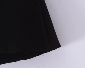 Primer plano de un top palabra de honor de punto negro con costuras finas y suaves