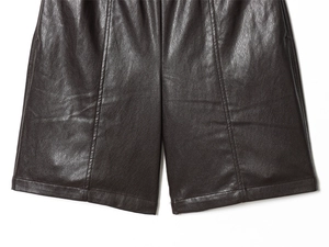 Detailed close-up showing the premium PU leather texture and central seam of brown shorts