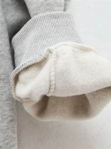 Détail macro du sweat gris montrant la doublure en polaire épaisse et le poignet côtelé