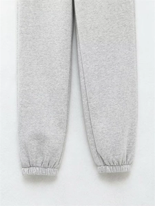 Détail du jogging gris montrant les poignets côtelés et la texture en coton doux