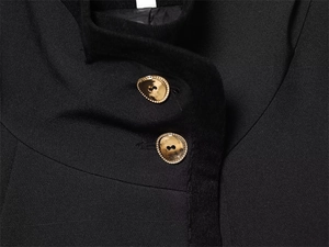 Macro shot of stylish gold irregular metal buttons on a black woven short jacket