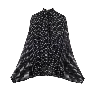 Detailansicht des Schluppen-Ausschnitts der schwarz-weißen Polka-Dot-Bluse
