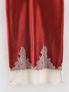 Detail of burgundy satin skirt hem featuring delicate cream eyelash lace trim contrast