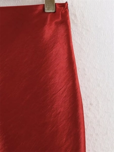 Detailed view of red satin fabric with elegant silk-like luster and smooth texture