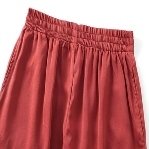 Détail de la taille élastique et des poches latérales sur ce pantalon large rouge brique