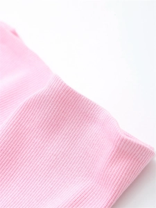 Macro detail of soft light pink ribbed knit fabric showing elastic texture and stitching
