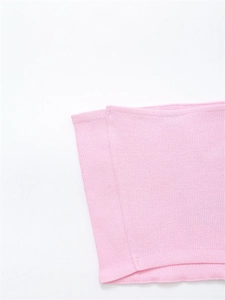 Detail of pink ribbed knit fabric showing vertical texture and thick rolled edge craftsmanship