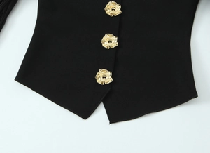 Détail de boutons roses dorés et ourlet symétrique sur un haut noir extensible