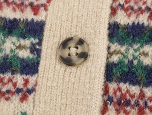 Nahaufnahme einer Strickjacke mit Fair-Isle-Muster und einem Knopf in Schildpatt-Optik