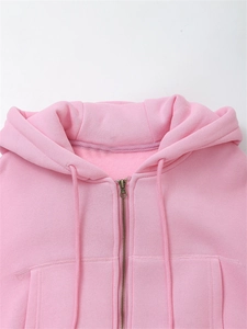 Detailed close-up of pink zip-up hoodie showing metal zipper and fine stitching texture