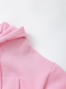 Detail of light pink hoodie showing high-quality stitching and soft fleece texture