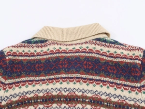 Detailansicht des beigen Rippkragens und des farbenfrohen Jacquard-Strickmusters am Pullover