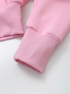 Detail shot of the pink cropped hoodie featuring elastic ribbed cuffs and soft cotton fabric