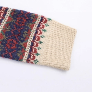 Nahaufnahme von Strickware mit Fair-Isle-Muster, bunten Geometrien und gerippten Bündchen