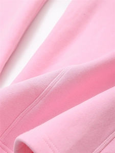 Macro shot showing high-quality stitching and soft pink knit fabric on a hoodie